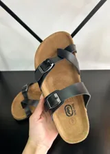 Sandalias de dedo negras con tiras finas de ecocuero y hebillas metálicas ajustables.