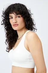 Top deportivo blanco de diseño seamless con escote en V y breteles anchos.