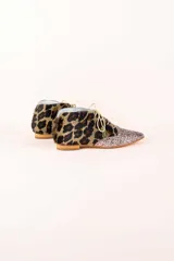 Botines acordonados con estampado animal print y puntera cubierta de glitter plateado.