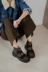 Botas cortas de cuero marrón con punta cuadrada y paneles de cuero liso y gamuza. Presentan elásticos laterales y suela track.