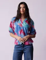 Blusa de gasa estampada marca Sioni, con cuello a la base y escote en V. Tiene mangas 3/4 con terminación fruncida.