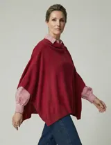 Poncho tejido de punto grueso, color mostaza/mostaza oscuro, con cuello redondo y caída amplia.