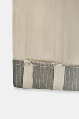 Jeans de tiro medio color beige, corte relaxed leg y largo al tobillo. Cuentan con cinco bolsillos y bajo con vuelta a contraste en gris. Cierre frontal con cremallera y botón.