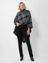 Capa tipo poncho de tejido grueso, con estampado tartán en tonos de gris, negro y blanco. Presenta cuello alto que se ajusta con un lazo o broche en el lateral.