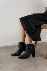 Botas de cuero color borgoña con punta fina y taco cuadrado. Cierre con cremallera dorada en la parte posterior.