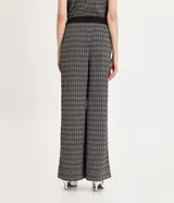 Pantalón wide leg de malla crepé con estampado geométrico en blanco y negro, cintura alta con doble abotonadura.