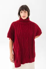 Poncho color vino con cuello alto y diseño de punto trenzado.
