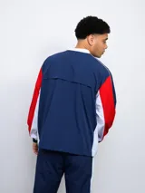 Buzo deportivo azul marino, rojo y blanco con escudo del Club Nacional de Football en el pecho y logo de Umbro en la manga.