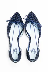Bailarinas con aberturas laterales, de raso flocado azul noche con estampado animal print. Cuentan con cordón de cola de ratón en el mismo tono, lazada delantera y plantilla de lana intercambiable.