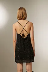 Minivestido negro con breteles finos, escote recto y apliques de strass plateados.