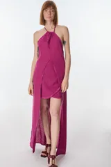 Conjunto de top halter con abertura en el abdomen y falda cruzada con ruedo desflecado, color fucsia.