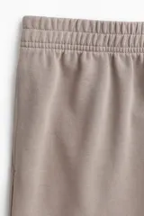 Pantalón de corte relajado color gris topo, confeccionado en felpa liviana de mezcla de algodón. Cuenta con cintura elástica fruncida, bolsillos laterales discretos y piernas rectas.