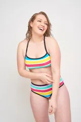 Conjunto de bikini con corpiño entero adelante, todo cruzado tipo acordonado en la espalda y bombacha de tiro alto con estampado a rayas horizontales de colores.