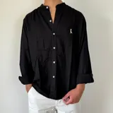 Camisa negra de lino con cuello mao, manga larga y corte regular.