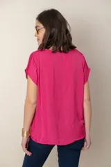 Blusa fucsia de seda con escote en V y mangas cortas.