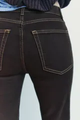 Pantalón de jean marrón oscuro, de tiro alto, corte slim fit y bootcut, con cinco bolsillos y pespuntes a contraste.