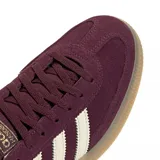 Zapatillas Adidas Handball Spezial color borgoña con las tres rayas laterales en blanco y suela de goma color caramelo.