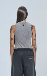 Musculosa gris claro con efecto gastado (acid wash), corte ajustado (slim-fit) y cuello redondo con terminaciones deshilachadas o con ojales pequeños.