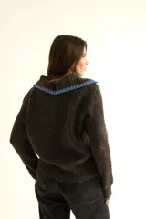 Cárdigan marrón de tejido con relieve, cuello camisero, botones al frente y detalles de color celeste en cuello y puños.