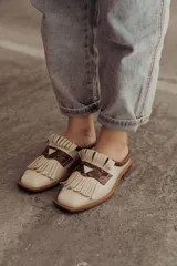 Zueco de cuero color crudo con detalle de flecos y pieza central en cuero snake.