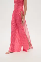 Pantalón largo de tela fluida con estampado de cebra en tonos rosa y fucsia. Tiene corte ancho y aberturas laterales con detalle de argollas.