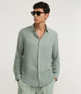 Camisa de hombre color verde menta, confeccionada en algodón texturizado con patrón melange. Presenta cuello inglés, manga larga y abotonado frontal. El corte es de estilo comfort, más generoso en sus medidas para mayor comodidad.