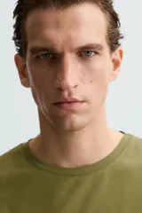 Camiseta marrón de corte slim fit, confeccionada en tejido de algodón con elasticidad, cuello redondo y manga corta.