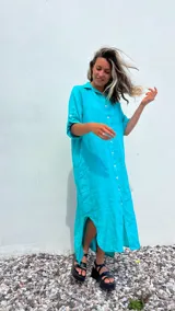 Vestido camisero largo color verde agua, confeccionado en lino 100%, con cuello camisero, abotonadura frontal completa, mangas 3/4 con trabilla y bolsillos laterales.