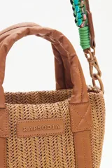 Cartera tote mini color negro, confeccionada en tejido tipo rafia. Cuenta con bolsillos internos, dos correas desmontables y abertura superior con cierre.