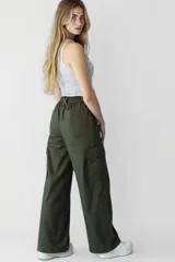 Pantalón negro de tiro alto, corte palazzo y bolsillos laterales.