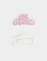 Set de dos broches para el pelo, uno con acabado de resina rosa y blanco, y otro de plástico blanco con forma geométrica.