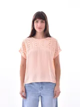 Blusa color durazno con detalle de calado en la parte superior y mangas cortas.