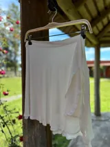 Pareo corto de color blanco con corte irregular.