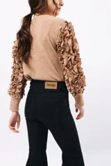 Remera negra de punto con mangas largas abullonadas con volantes.