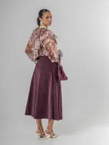 Falda midi de micro pana color morado oscuro, de corte recto y cintura elastizada. Incluye un cinturón desmontable de cuero marrón.