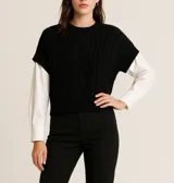 Sweater negro de punto con cuello redondo y mangas cortas.