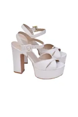 Sandalias de cuero color crema con tiras cruzadas, pulsera ajustable al tobillo, tacón de bloque alto y plataforma delantera.