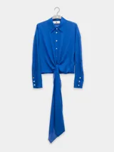 Camisa azul eléctrico de algodón con botones nacarados, corte holgado, mangas largas con puños abotonados y lazo en la cintura.