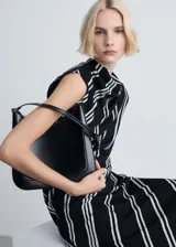 Vestido midi con estampado de rayas verticales blancas sobre fondo negro, cuello perkins, manga corta asimétrica y cierre de cremallera en la espalda. Tejido fluido con acabado satinado y forro interior.