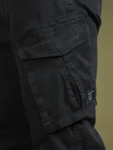 Pantalón cargo color marrón con bolsillos laterales con solapa y corte ajustado.