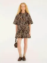 Vestido corto con estampado de leopardo, confeccionado en tejido liviano. Cuenta con escote redondo, mangas cortas y bajo en capas con acabado ondulado.