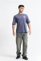 Remera oversize azul con estampado en la espalda que incluye una flor abstracta y la palabra 'blurred'.