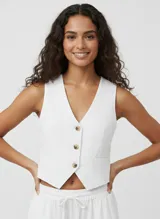 Chaleco blanco de lino y viscosa con cierre de botones y bolsillos laterales. Tejido ligero y elegante.