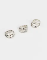 Set de tres anillos plateados con diferentes diseños: uno liso de tres aros, otro con diseño entrecruzado y otro con tres aros separados.