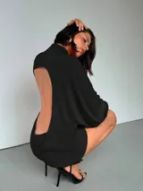 Minivestido negro de mangas largas con cuello alto.