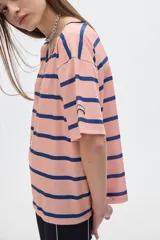 Remera oversized de rib a rayas horizontales color salmón y azul marino, con cuello redondo negro y mangas cortas.