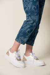 Zapatillas urbanas de cuero vacuno color beige, con detalles en verde oliva y rosa pastel.
