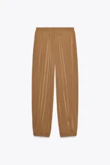 Pantalón de tiro medio color marrón claro, con cintura elástica, bolsillos laterales ocultos y puños elásticos.