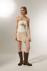 Minifalda color beige con diseño cruzado y detalle de bolsillo lateral.