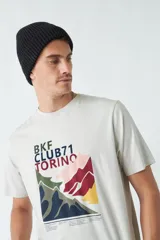 Remera azul marino de hombre con cuello redondo y estampado de montañas en tonos verde, amarillo y blanco.